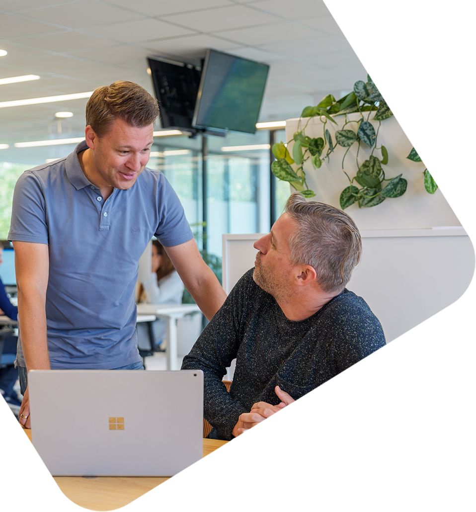 Twee collega's overleggen bij laptop in moderne kantooromgeving van Bluedesk